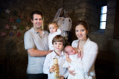 Happy young family with three children celebrating the baptism